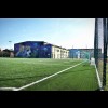 Boisko do piłki nożnej , budynek nowej sali sportowej z namalowanym rysunkiem małego chłopca z piłką 