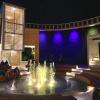 Widok atrium tężni solankowej po zmierzchu, wypełnionego efektami świetlnymi oświetlenia iluminacyjnego fontanny posadzkowej oraz iluminacji klatki schodowej i ścian z tarniny.