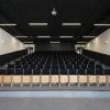 Sala audiowizualna szkoły. Kilkanaście rzędów krzeseł widzianych z dołu.