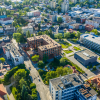 Szeroka panorama z lotu ptaka na Kwartał Rzeczna w Rybniku, z widocznym budynkiem Towarzystwa Budownictwa Społecznego i otaczającymi zabudowaniami.