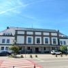 Frontowa część budynku Gminnego Ośrodka Kultury w Goleszowie z widocznym wejściem głównym i parkingiem oraz prowadzącym do niego przejściem dla pieszych.