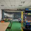 Sala Games Room w pckulu z automatami retro, stołami do gier planszowych i fototapetą z motywem gry Fallout. 
