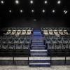 Nowoczesna sala kinowa Pszczyńskiego Centrum Kultury z ciemnymi fotelami i centralnymi schodami podświetlonymi niebieskimi liniami LED.